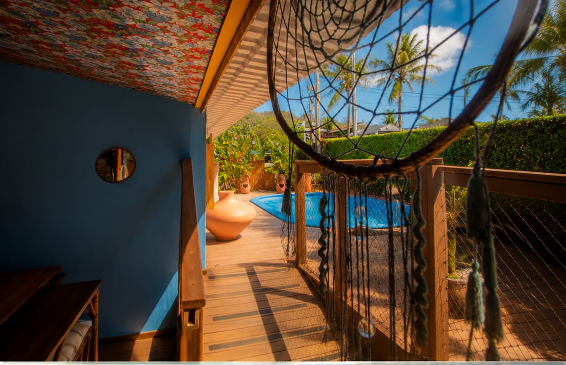 Piscina vista de uma varanda com cadeira suspensa