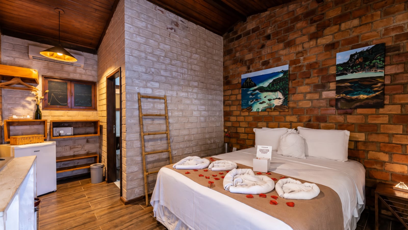 Apartamento com cama de casal, parede de tijolos e obras sobre Fernando de Noronha